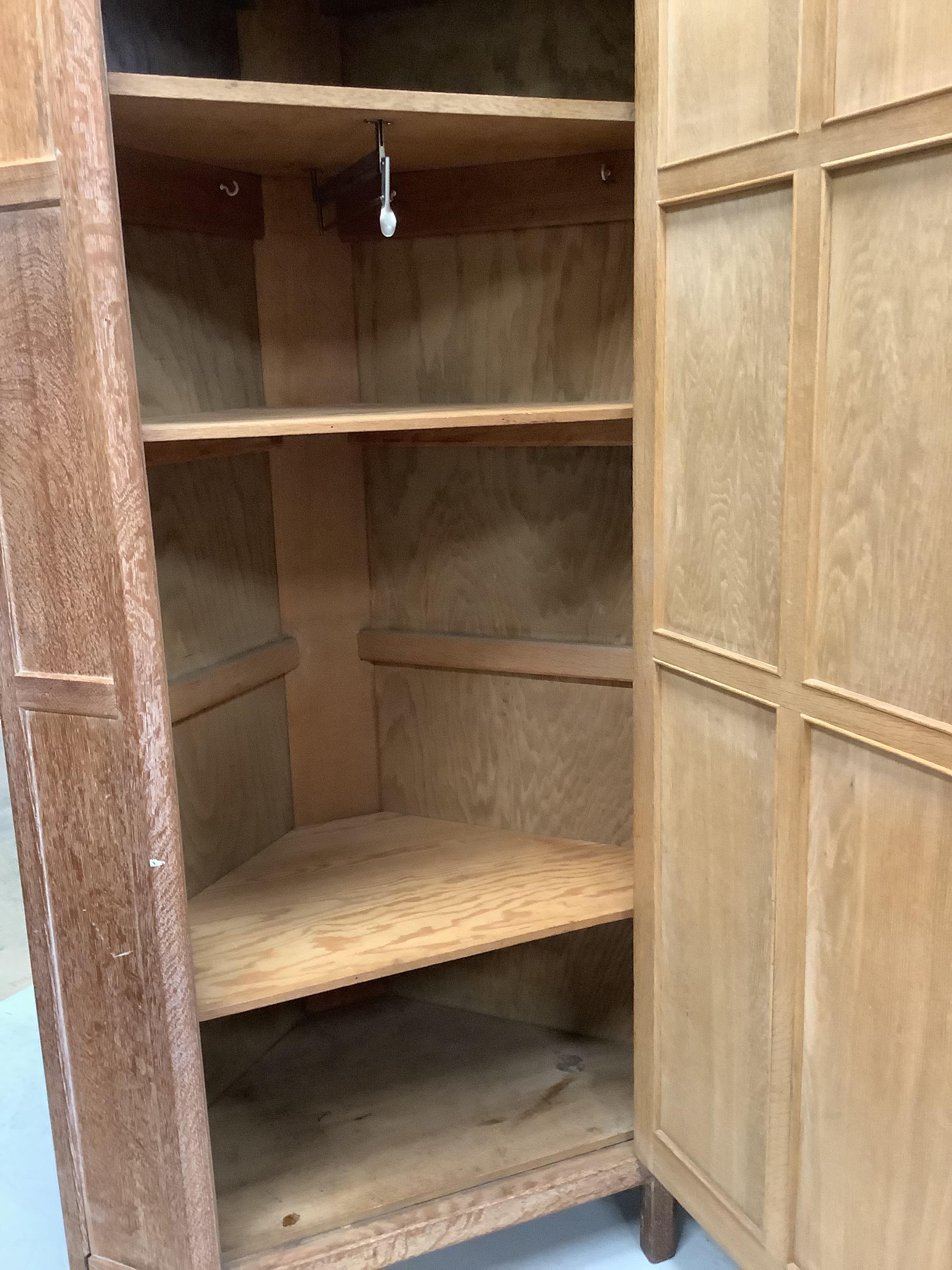 Heal & Son Ltd., London, a pair of bleached oak corner wardrobes, width 94cm, depth 53cm, height 182cm